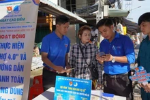 Youth union members guide vendors on cashless payments at My Ngai Market, Ward 1, Cao Lanh City.