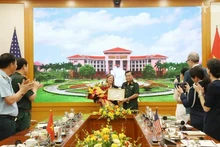 Deputy Defence Minister Senior Lieutenant General Hoang Xuan Chien (R) presents a certificate of merit from the Minister of National Defence of Viet Nam to USAID's Mission Director for Vietnam Aler Grubbs (Photo: VNA)