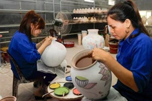 Painting patterns on ceramic products at Bat Trang Pottery Village. (Photo: DANG ANH)