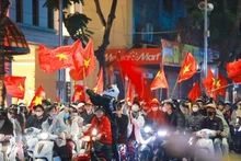 Residents in Ha Noi celebrate the Vietnamese U22 team's win at the 33rd SEA Games on December 18 evening. (Photo: VNA)