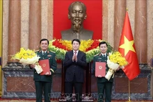 State President Luong Cuong (middle) presents congratulatory flowers to the two promoted officers (Photo: VNA)