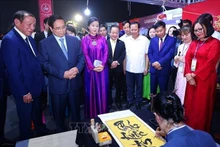 PM Pham Minh Chinh visits a Vietnamese booth at the event (Photo: VNA)