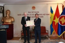 Ambassador Tran Van Tuan (R) presents the “For the Cause of Culture, Sports and Tourism” insignia to Swedish filmmaker Bo Öhlén. (Source: Embassy of Viet Nam in Sweden)
