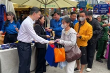 Representatives of the Organising Committee present gifts and lucky money to people before their departure home for Tet (Lunar New Year).