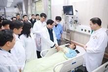 Prime Minister Pham Minh Chinh visits and extends Lunar New Year greetings to a patient undergoing treatment at Bach Mai Hospital. (Photo: VNA)