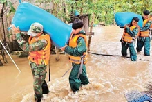 Officers and soldiers of the Dak Lak Provincial Military Command help people in Ea Sup commune move their assets to a safe place. (Photo: CONG LY)