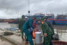Border guard officers at Ky Ha Port Border Gate are assisting residents in securing their boats. (Photo: VNA)