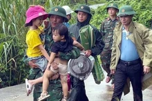 Border guards at Ba Nang Border Guard Station, Quang Tri Province, help children move to safety. (Photo: VNA)