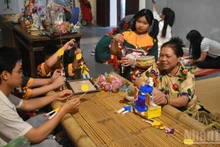 Artisan Nguyen Thi Tuyen introduces “paper doctor” toys to young people.