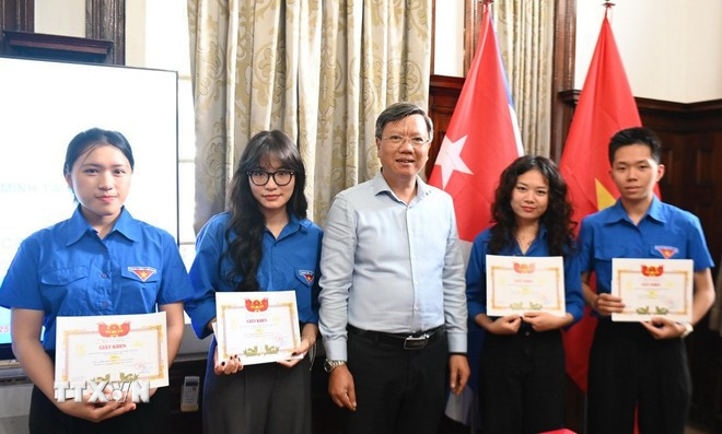 Party Secretary and Ambassador Le Quang Long presents certificates of merit to outstanding students and active participants in the Ho Chi Minh Communist Youth Union's movements in Cuba. (Photo: VNA)