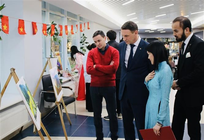 Visitors to a photo exhibition on the Vietnamese land and people. (Photo: VNA) Visitors to a photo exhibition on the Vietnamese land and people. (Photo: VNA)