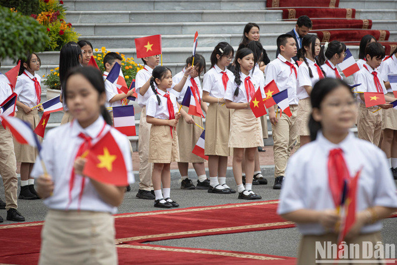Children from the capital greet French President Emmanuel Macron.