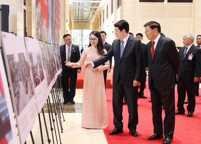 The Vietnamese and Lao leaders visit the photo exhibition organised by the Vietnamese News Agency. (Photo: VNA)