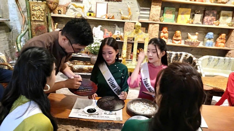 Contestants of the Miss Ao Dai Pageant engaged in traditional craft activities during their visit to Duong Lam Ancient Village.