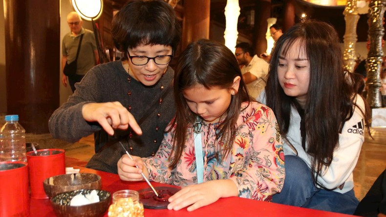 Artists and tourists creating lacquer works together at the Temple of Literature–Quoc Tu Giam Artists and tourists creating lacquer works together at the Temple of Literature–Quoc Tu Giam