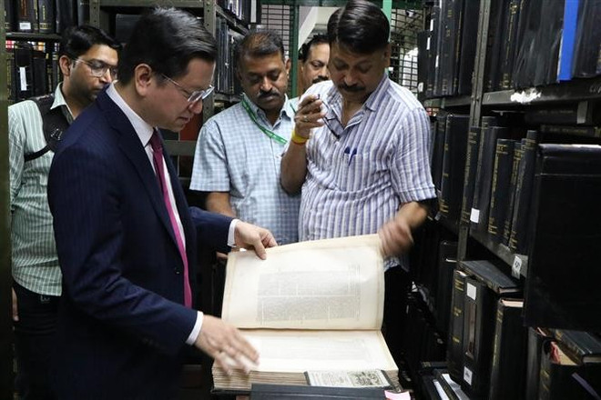 Ambassador Nguyen Thanh Hai reads one of the oldest books in the rare book archive of the Central Secretariat Library. (Photo: VNA)