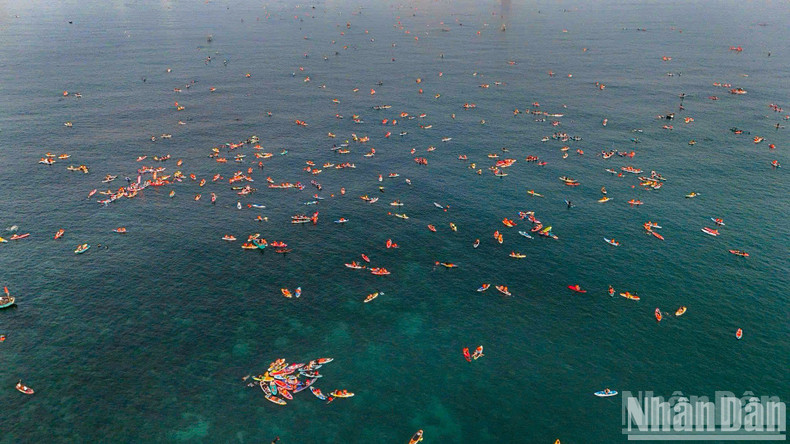 The sea glistens with colourful paddleboards. The sea glistens with colourful paddleboards.