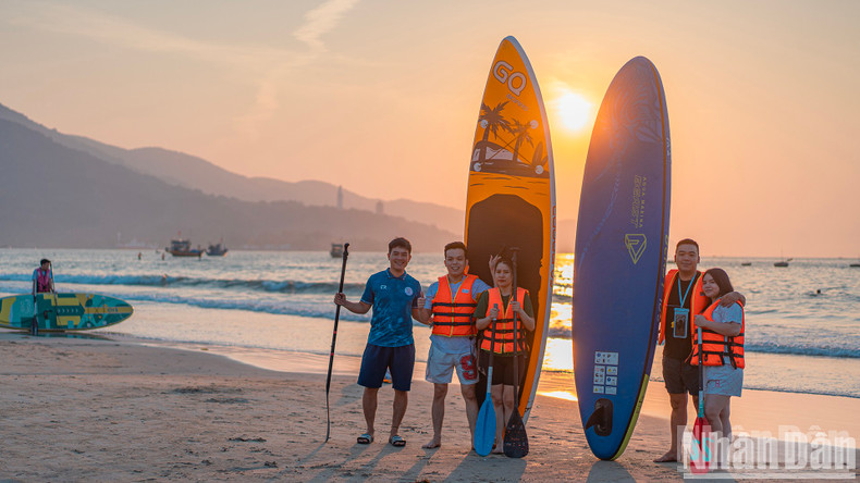 A SUP rental operator poses for a photo with a customer. A SUP rental operator poses for a photo with a customer.