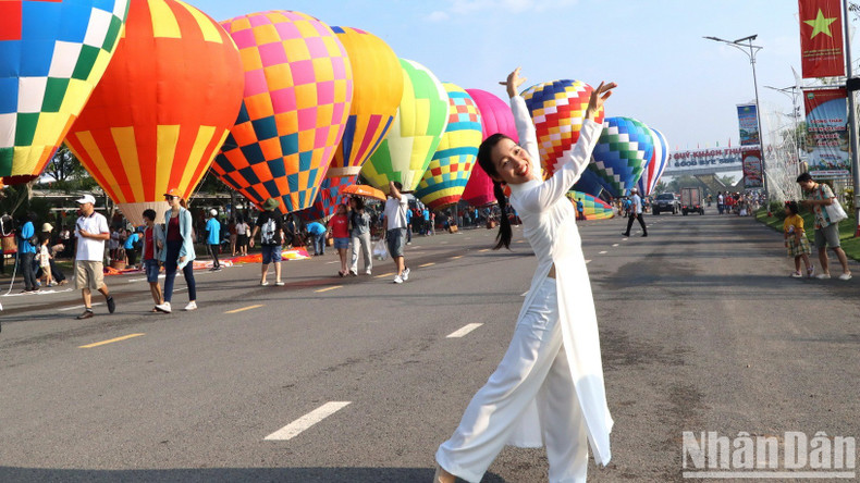 Visitors capturing memories beside the hot air balloons.