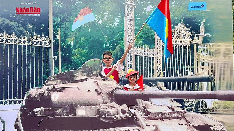 Brothers Minh Nhat and Nhat Anh capture memories at the exhibition. (Photo: NDO)