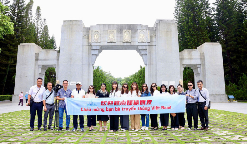 The reporters pose for a photo in front of the Huanghuagang Cemetery Park. anh4.jpg