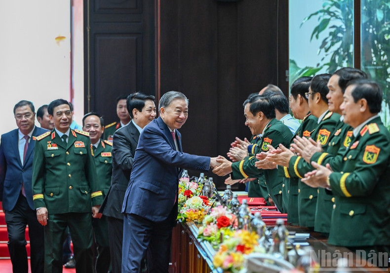 Party General Secretary To Lam and President Luong Cuong shake hands with delegates attending the congress. military2.jpg
