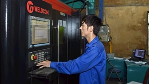Operating a mechanical manufacturing line at Tomerco An Khang Company, Ngoc Liep Industrial Cluster (Hanoi). (Photo: TUE NGHI)