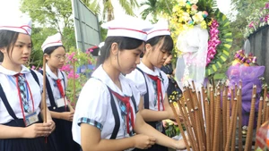 Students offer incense in memory of the 504 innocent civilians killed in the Son My Massacre 58 years ago. (Photo: VNA)