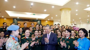 Party General Secretary To Lam (C) meets with outstanding delegates to the eighth congress of military women for the 2025–2030 tenure. (Photo: VNA)