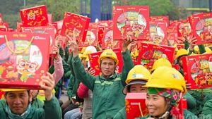 Construction workers at the Pearl Theatre project site (Ha Noi) joyfully receive Tet gifts from the organisers of the “Xay Tet 2026” programme.