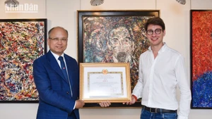 Ambassador Dinh Toan Thang presents the A-prize certificate to artist Georg Esco. (Photo: MINH DUY)