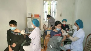 Medical staff administer vaccinations to students at a provincial school in Hung Yen.