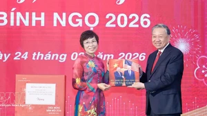 VNA General Director Vu Viet Trang (L) presents a photo book to Party General Secretary To Lam. (Photo: VNA)