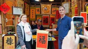 International visitors experience the traditional new year calligraphy activity (Photo: VNA)