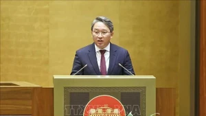 Minister of Justice Nguyen Hai Ninh presents a report on revisions to the draft resolution. (Photo: VNA)