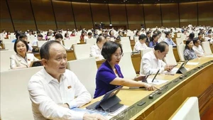 Deputies press buttons to vote on laws and resolutions at the 15th NA's 9th session. (Photo: VNA)