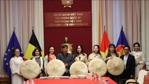 Do Phuoc Trung, Deputy Director of the Ho Chi Minh City Department of Culture and Sports, presents non quai thao to the Vietnamese Ao Dai Heritage Club in the Kingdom of Belgium.