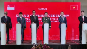 Vietnamese Deputy Minister of National Defence Sen. Lieut. Gen. Hoang Xuan Chien (third, right) and delegates launch Viettel’s representative office in Singapore. (Photo: VNA)