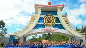 Delegates pose for a commemorative photo at the Bo Y International Border Gate. (Photo: doanthanhnien.vn)
