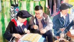 Visitors experience the traditional craft of creating beeswax patterns at the community tourism site of Sung village, Cao Son commune.