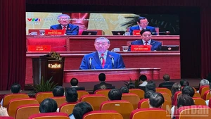 Members of the Vietnamese community in Laos attentively listen to the presentation of the report on documents submitted to the 14th National Congress by Party General Secretary To Lam. (Photo: Trinh Dung)