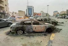 Cars are destroyed after clashes in Tripoli. (Photo: VNA/Xinhua)