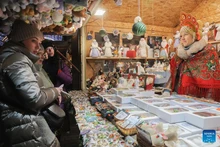 Tourists buy souvenirs at a Christmas market in St. Petersburg, Russia, Dec. 13, 2025. A Christmas market opened here on Saturday for the upcoming Christmas and New Year holidays. (Photo: Xinhua)