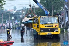 A rescue boat is transported by a crane truck through a flooded street in Colombo, Sri Lanka, on Dec. 1, 2025. The death toll from extreme weather conditions hitting Sri Lanka has risen to 410, while 336 people remain missing, the country's Disaster Management Center said Tuesday. (Photo: Xinhua)