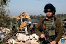 Israeli soldiers are seen as an Israeli military excavator demolishes a Palestinian home in the town of Beit Awa, west of Hebron in the West Bank, on Feb. 5, 2026. (Photo: Xinhua)