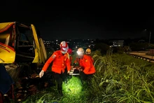 This photo provided by Indonesia's National Search And Rescue Agency (Basarnas) Semarang region shows rescuers transferring an injured passenger after a bus crash in Semarang, Central Java, Indonesia, Dec. 22, 2025. At least 15 people were killed and 19 others injured after a long-distance bus crashed at a toll road exit in Semarang, Central Java, Indonesia, early Monday, the local search and rescue authority said. (Basarnas Semarang/Handout via Xinhua)