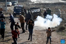 Palestinians take shelter from tear gases fired by Israeli forces in the village of Tarqumiyah, west of Hebron in the West Bank, on Nov. 28, 2025. Israeli security forces and settlers have killed 1,030 Palestinians in the occupied West Bank, including East Jerusalem, since Oct. 7, 2023, the United Nations Office of the High Commissioner for Human Rights (OHCHR) has verified, a UN spokesperson said here Friday. (Photo: Xinhua)