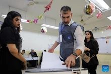 A staff member assists voters to put their ballots into a ballot box at a polling center in Baghdad, Iraq, on Nov. 11, 2025. Iraqis began to vote in parliamentary elections on Tuesday morning for a new 329-member Council of Representatives. (Photo: Xinhua)