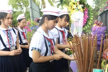 Students offer incense in memory of the 504 innocent civilians killed in the Son My Massacre 58 years ago. (Photo: VNA)