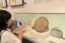 Visitors admire fine art masterpieces from the Ly–Tran dynasties. (Photo: Chieu Anh)